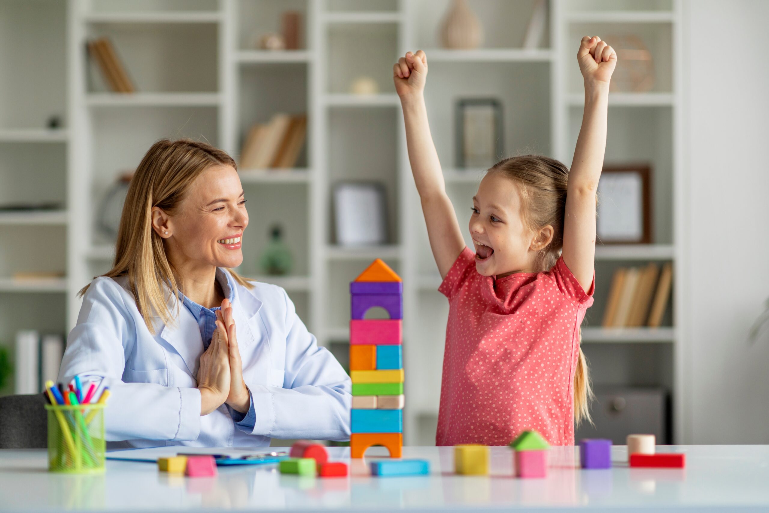 cute,little,girl,and,child,development,specialist,celebrating,therapy,progress