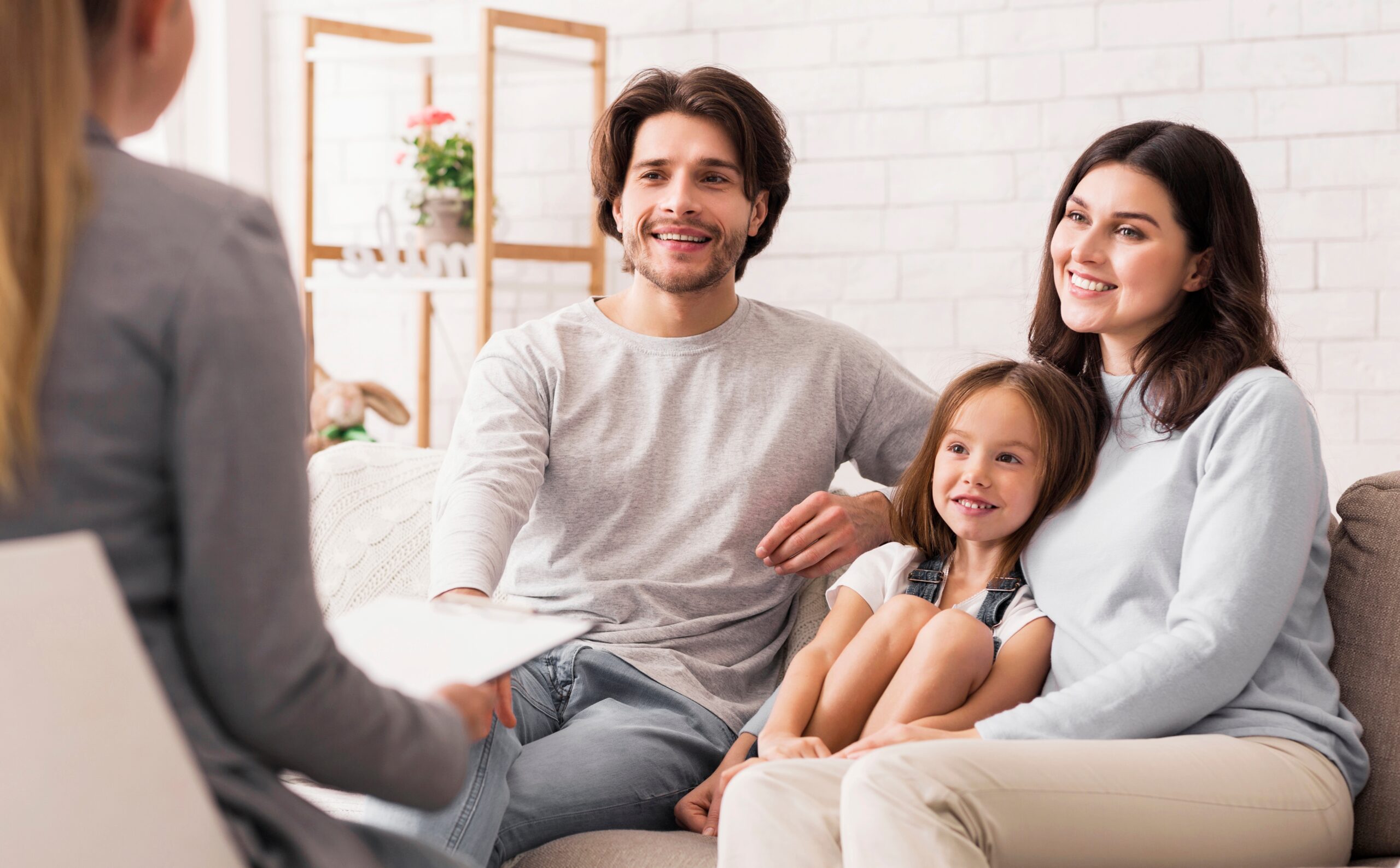 happy,parents,with,little,daughter,sitting,together,at,psycholigist's,office
